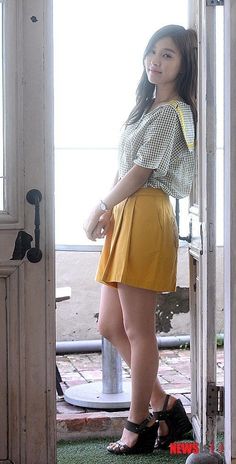 a woman standing in front of an open door with her hand on her hip and looking at the camera