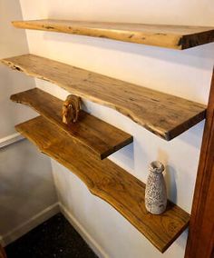 two wooden shelves on the wall, one with a vase and another with an animal figurine