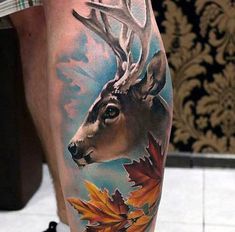 a man's leg with a deer and leaves on it