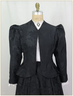 "Poly Jacquard. Color: Black. Beautiful woven jacquard satin fabric in rose pattern design. Fitting darts front and back and shoulder pleated Victorian two piece sleeves. Unlined jacket perfect for outdoor wear in all weather. Matching satin jacquard skirt and belt sold separately. Dry clean. Circa 1890-1905. Made in U.S.A. Sizes: SM, MED LG & XLG. Jackets ordered by bust measurement, inches: BUST         SIZES 32\" - 34\"   SMALL 35\" - 39\"   MEDIUM 40\" - 44\"   LARGE 45\" - 49\"   XLARGE Jac Classic Fitted Satin Outerwear, Fitted Classic Satin Outerwear, Fitted Jacquard Outerwear For Fall, Fitted Black Satin Blazer, Classic Long Sleeve Jacquard Outerwear, Fitted Jacquard Blazer With Long Sleeves, Black Satin Outerwear For Fall, Black Satin Long Sleeve Outerwear, Fitted Satin Outerwear For Fall