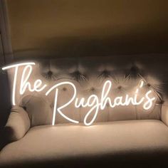 the rughan's neon sign is lit up on a couch