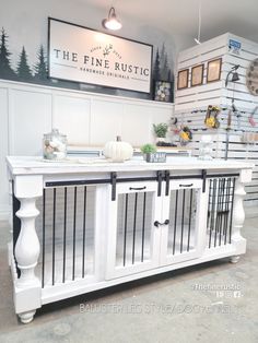 the fine rustic store has white cabinets and black bars on it's front doors