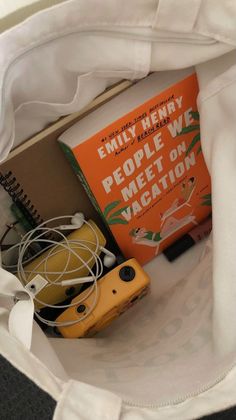 an open book and camera in a white bag