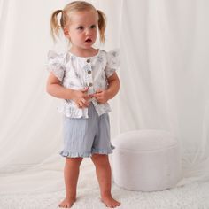 Get ready for some summer fun with the Aliya Skye Short and Top set! These super soft cotton shorts feature an elastic waist for ultimate comfort, while the top boasts flutter sleeves and buttons down the front. Perfect for any little girl, this outfit is sure to become her go-to choice. Wash cold with like colors Lay flat to dry; Minor shrinkage likely if tumble dried 100% cotton Summer Playwear Tops With Elastic Waistband, Summer Playtime Ruffle Bloomers, Spring Ruffled Shorts For Playwear, Spring Playwear Shorts With Ruffles, Cotton Tops With Elastic Waistband For Playwear, Spring Playwear Short-sleeved Tops, Summer Ruffled Short Tops, Ruffled Bottoms For Summer Playtime, Short Sleeve Playwear Sets With Ruffles