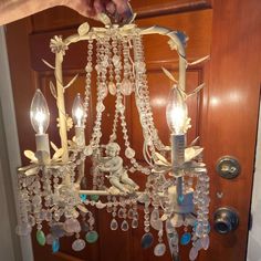 a chandelier hanging from the ceiling in front of a door with glass beads