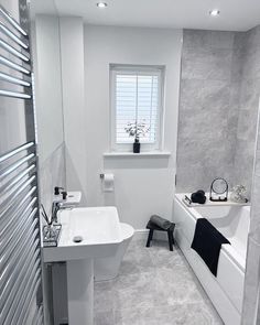 a bathroom with a sink, toilet and bathtub next to a radiator