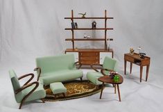 a doll sitting on a green couch in front of a coffee table and two chairs