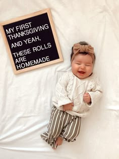 a baby is laying down next to a sign that says my first thanksgiving and yeah, these rolls are homemade