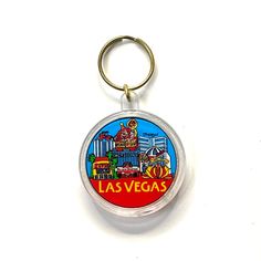 the las vegas keychain is hanging from a metal ring on a white surface