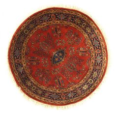 a round rug with an intricate design on the center and fringes around the edges