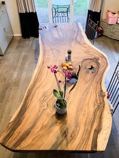 a wooden table with vases and flowers on it in a living room next to a door