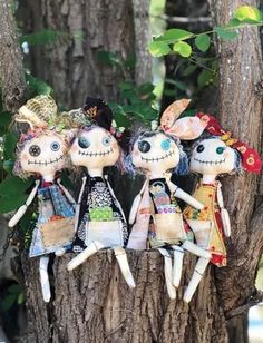 three dolls sitting on top of a tree