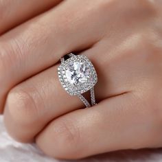 a woman's hand with a diamond ring on top of her finger and an engagement band