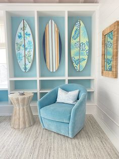 a living room with surfboards on the wall and a blue chair in front of it