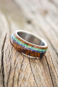 Product Details Ring Style: "Remmy" is a custom, handcrafted men's wedding ring featuring a redwood overlay with blue opal and malachite inlay on a titanium band. Both the blue opal and the malachite are mixed with opal. Additional inlay options are available upon request. Width: The width of the ring pictured is approximately 7-8mm wide but can be ordered in a custom width for a small upgrade cost. Please state your desired width in the Notes to Seller section during checkout, and we will reach Men's Wedding Ring, Detailed Ring, Ring Pictures, Handcrafted Rings, Unisex Ring, Ring Style, Gold Wedding Band, Ring Collections, Womens Engagement Rings