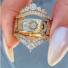 a woman's hand holding a gold ring with diamonds on it