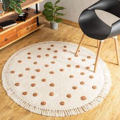 a white rug with brown polka dots on it in a living room next to a black chair