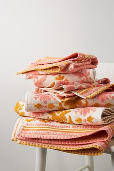 stack of folded towels sitting on top of a white chair