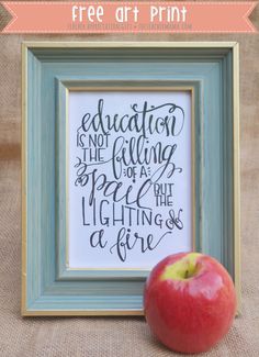 an apple sitting next to a frame with the quote education is not the filling of a spell but lightening and a fire