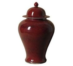 a large red vase with a lid on the top is sitting in front of a white background