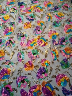 an image of colorful fabric with flowers on the side and sequins all over it