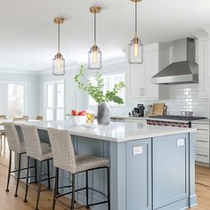 a kitchen island with four stools in front of it and an oven on the other side