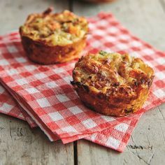 two muffins sitting on top of a red and white checkered napkin