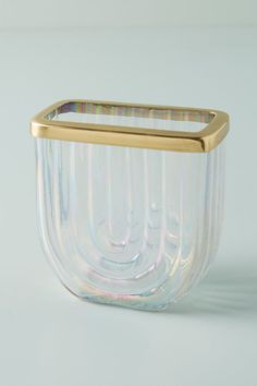 a glass vase with a gold rim on a white background