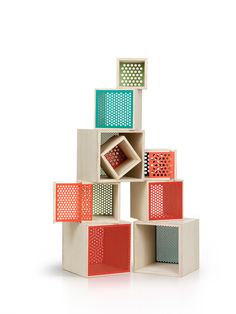 a stack of different colored boxes with holes in the top and bottom, on a white background