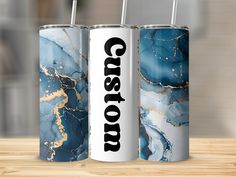 two blue and white canisters with the word coast on them sitting on a wooden table