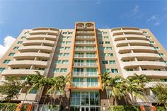 an apartment building with palm trees in front