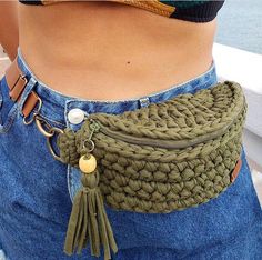 a close up of a woman's waist wearing a belt with tassels