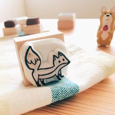 a close up of a napkin on a table with two small animals in the background