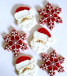 four decorated cookies with santa claus and snowflakes