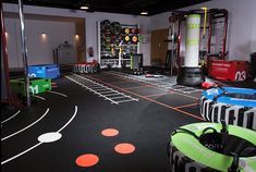 an indoor gym area with various equipment and accessories on the floor, including exercise mats