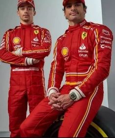 two men in red racing suits sitting next to each other