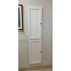 a tall white cabinet sitting in the corner of a room