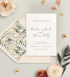 the wedding stationery is laid out next to flowers