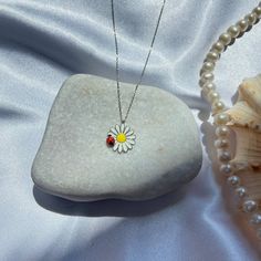 A charming daisy and ladybug pendant necklace featuring a whimsical floral design. The adjustable chain ensures a perfect fit for any occasion, making it an ideal gift for her. Crafted with high-quality materials, this delightful piece of jewelry adds a touch of fun and elegance to any outfit, perfect for both everyday wear and special occasions. ⭐ Chain Length: 17.7 inches ⭐ Materials: Silver ⭐ Nickel free hypoallergenic for sensitive skin.a ⭐ Lightweight, perfect for everyday wear. ⭐ All of our products are handcrafted and ± 10% deviation may occur in grams and sizes. ⭐ If you have any question, contact us freely. ⭐ The light color of the photos may vary on computer and phone.      --- Care Guide --- * Unfortunately, 925 sterling and all other silver types tarnish in time. So the questio Summer Flower Pendant Necklace With Flower Charm, Silver Daisy Necklace, Nature-inspired Silver Flower Necklace With Charm, Ladybug Necklace, Cute Daisy-shaped Jewelry With Flower Charm, Perfect Gift For Her, High Quality Jewelry, Ideal Gift, Daisy