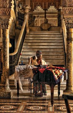 a man sitting at a table in front of a stair case