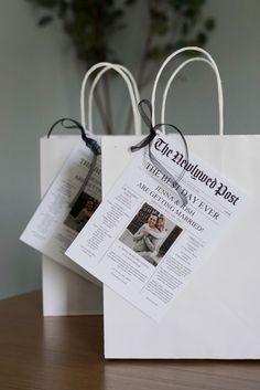 two white paper bags with tags attached to them