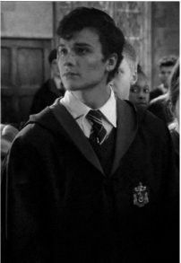 a young man wearing a harry potter outfit in front of a group of other people