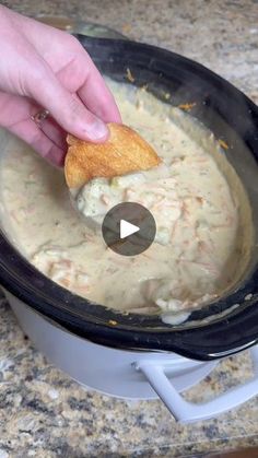 a person dipping some food into a pot