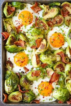 brussel sprouts with eggs and bacon are in a baking pan on the table