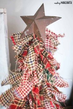 a christmas tree decorated with plaid ribbon and a star