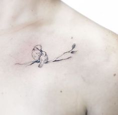 a small bird on a branch tattoo on the chest