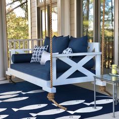 a porch swing with blue and white pillows