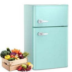 a blue refrigerator freezer sitting next to a box of fruit and vegetables