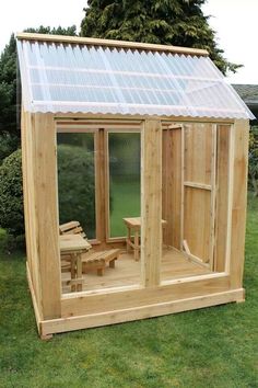 a small wooden shed with a glass roof