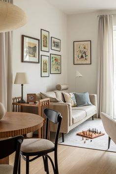 a living room filled with furniture and pictures on the wall next to a wooden table